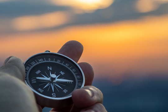 A compass held against a sunset